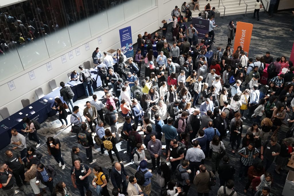 A large crowd of people in a conference building lobby
